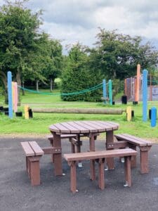 A photograph of a picnic bench and play equipment at woodhouse park in peterlee